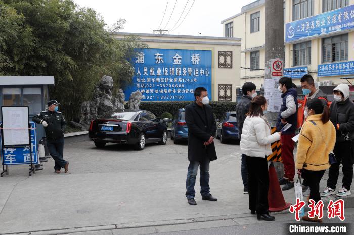 上海金桥劳务市场大门紧闭，应聘者与企业人士人员在街边谈论薪酬待遇。　殷立勤 摄